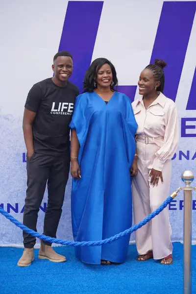 Pastors Josh and Joanne with a guest at the Life Conference banner